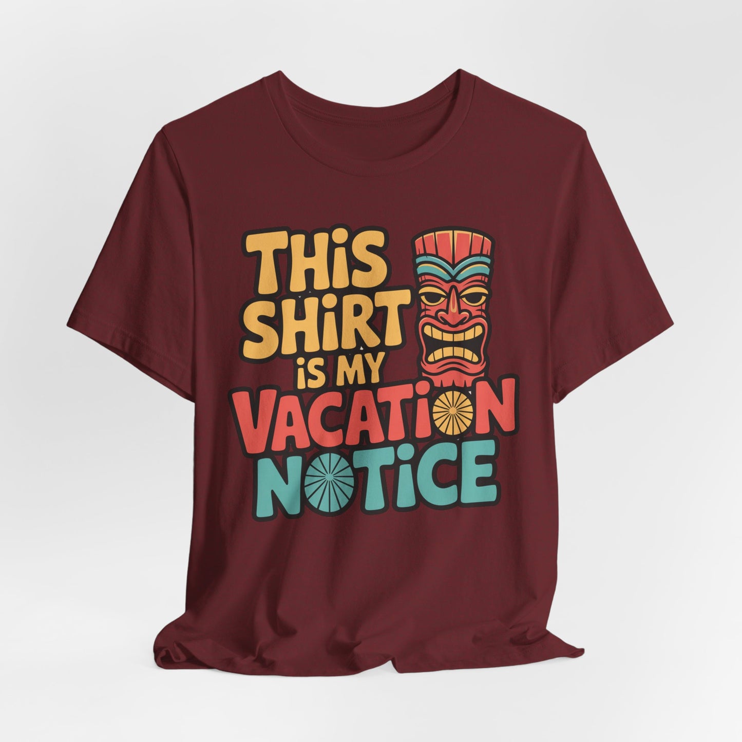 The Tiki T-Shirt - This Shirt is My Vacation Notice is a maroon unisex jersey tee featuring vibrant vacation-themed text and an illustrated tiki mask, perfect for travel lovers.