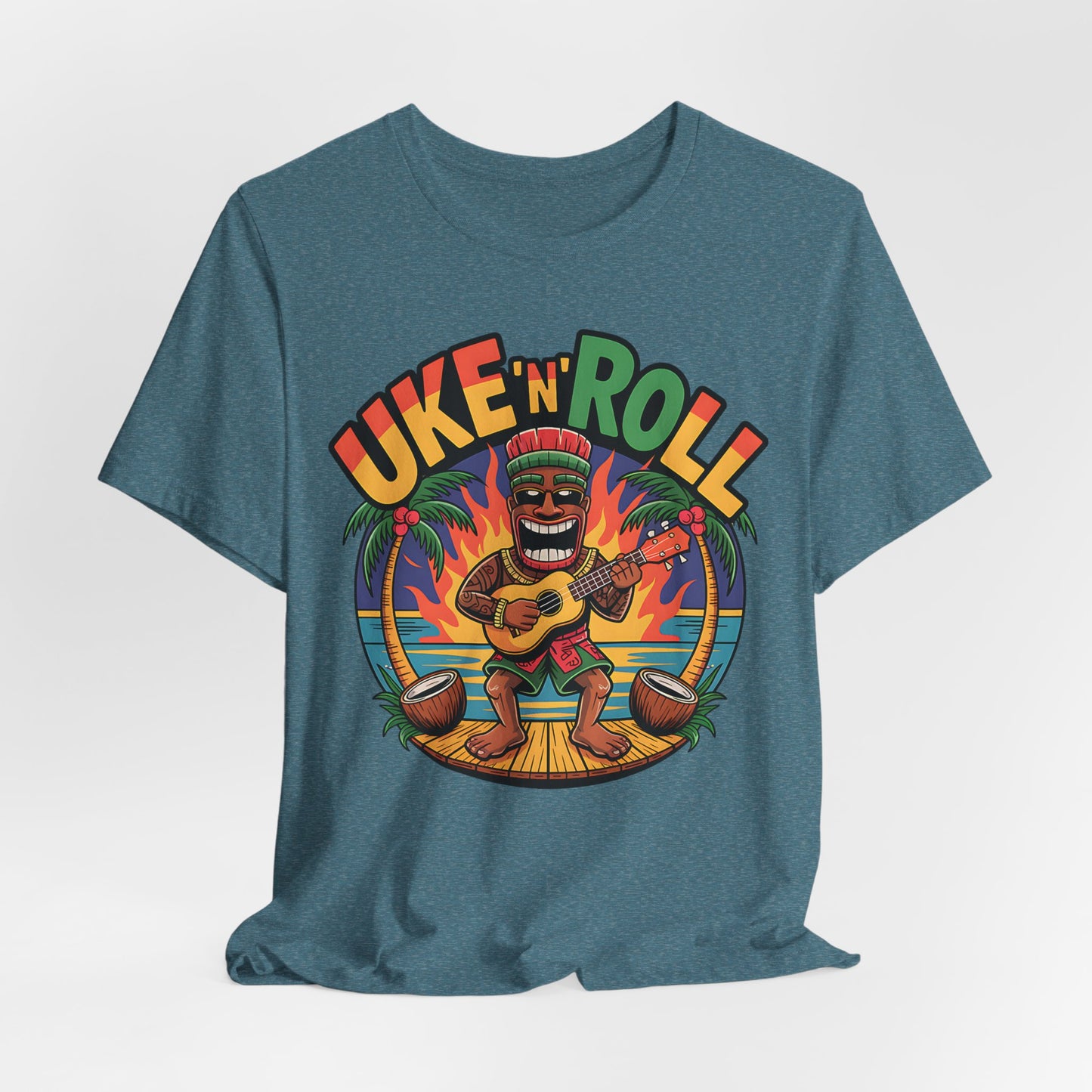 The Uke n Roll Unisex Jersey Tiki T-Shirt features a cartoon tiki playing ukulele on a sunset beach with palm trees, coconuts, and bold UKE N ROLL lettering—perfect for music lovers and beach vibes.