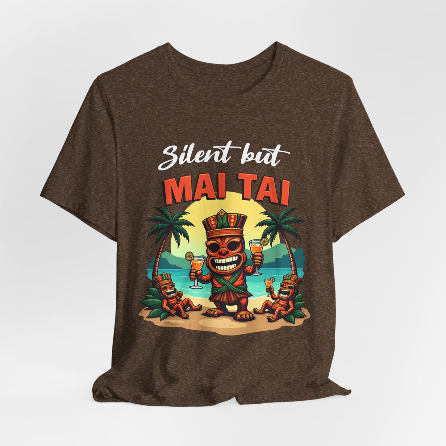 The Mai Tai Graphic Unisex Jersey Tiki T-Shirt features a vibrant cartoon tiki with drinks, two smaller tikis, palm trees, and a beach sunset. Silent but MAI TAI text above makes it perfect for your next tropical getaway.