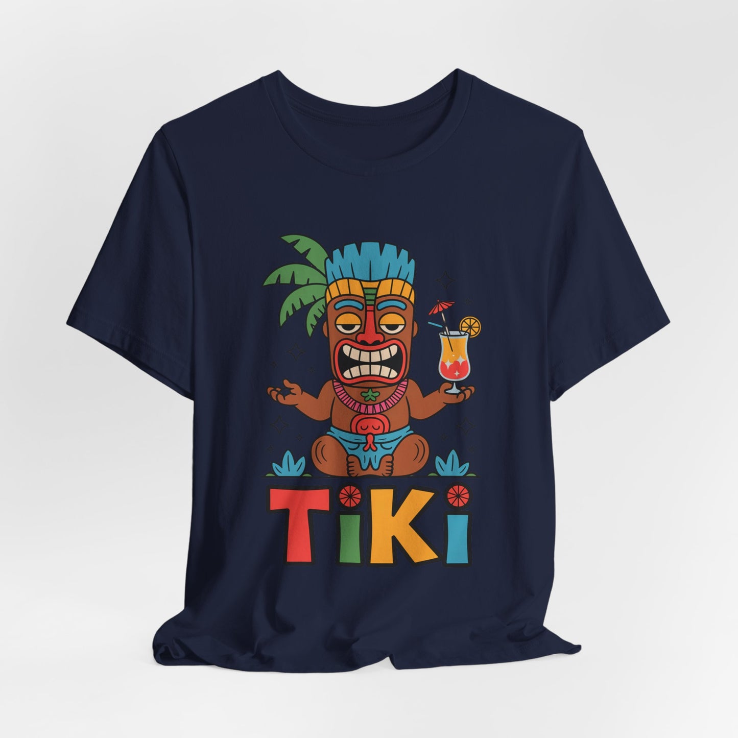 Celebrate summer in style with the Tiki Party Unisex Jersey Tiki T-Shirt—a navy blue tee featuring a vibrant cartoon tiki with a drink under a palm tree and bold multicolored “TIKI,” crafted with eco-conscious production.