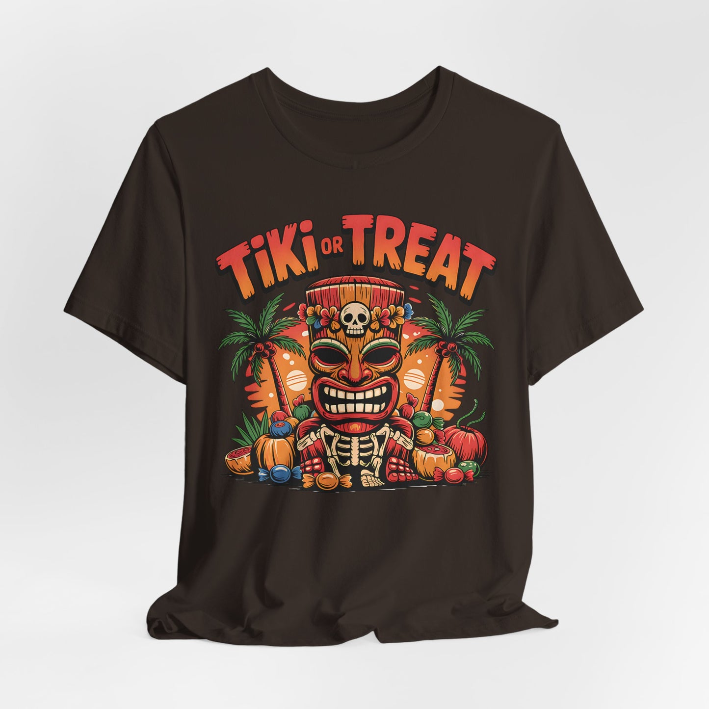 The Tiki or Treat Halloween Tiki T-Shirt is a unisex jersey short sleeve tee featuring a vibrant tiki mask with skull crown, pumpkins, candy, palm trees, and bold “Tiki or Treat” text—perfect for festive Halloween fun.