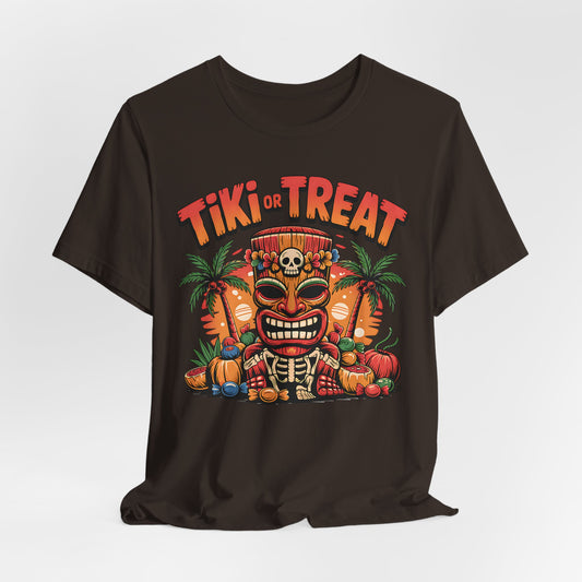The Tiki or Treat Halloween Tiki T-Shirt is a unisex jersey short sleeve tee featuring a vibrant tiki mask with skull crown, pumpkins, candy, palm trees, and bold “Tiki or Treat” text—perfect for festive Halloween fun.