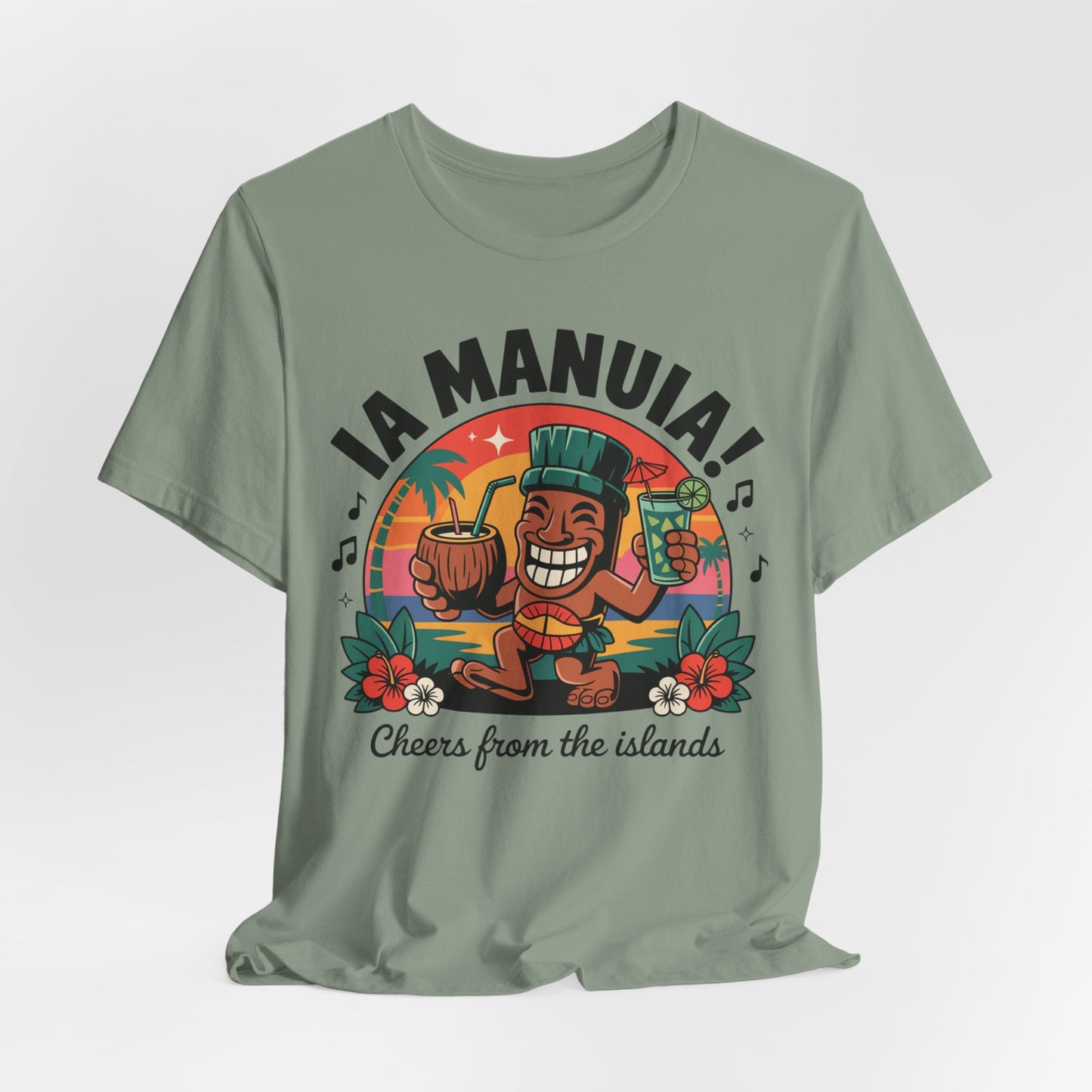 The IA MANUIA! Island Vibes Unisex Jersey Tiki T-Shirt features a green, breathable cotton tee with a vibrant cartoon tiki, drinks, flowers, palm trees, and sunset. IA MANUIA! Cheers from the islands is printed—ideal for tropical-themed events.