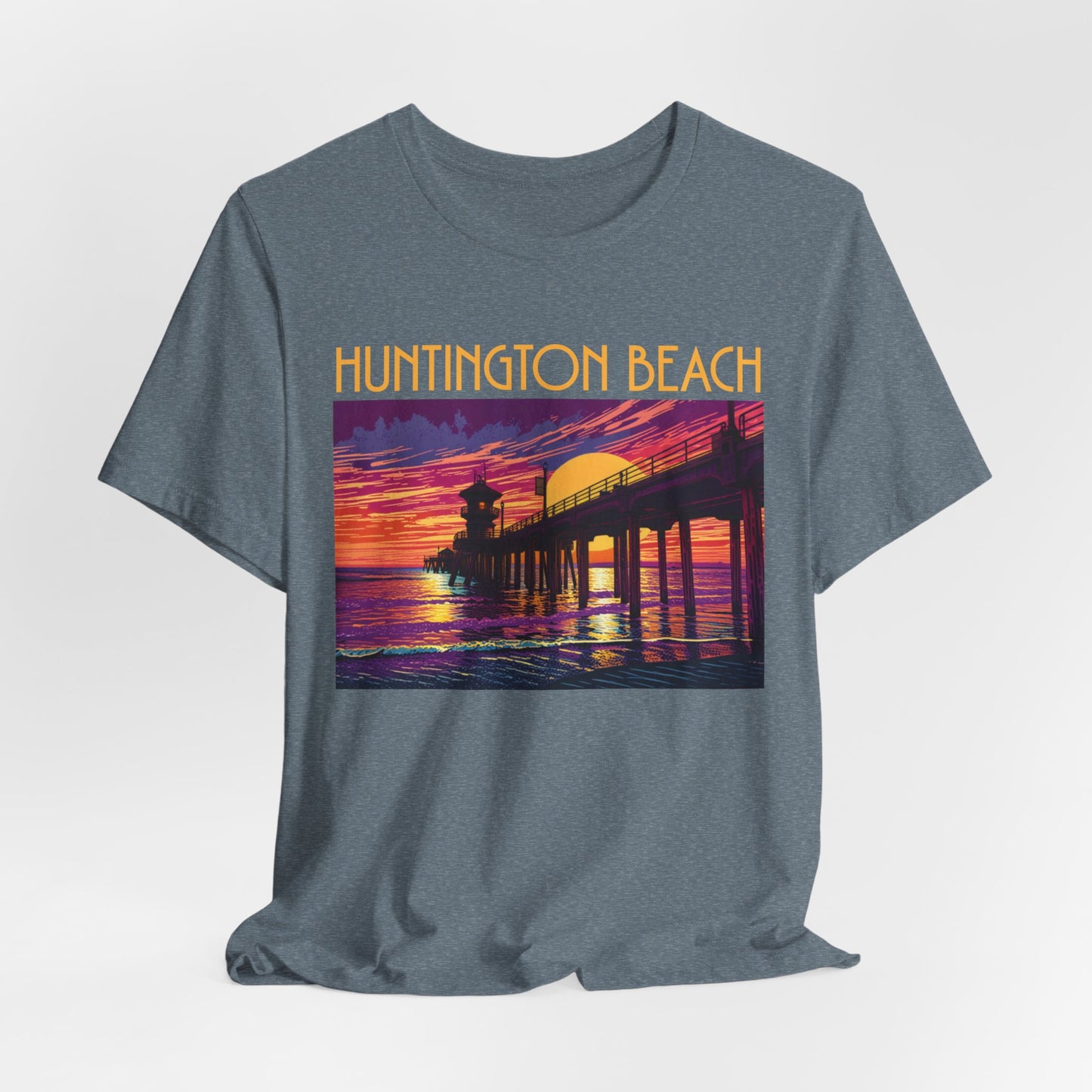 The Huntington Beach Sunset T-Shirt is a gray unisex jersey with a vibrant pier-at-sunset print and Huntington Beach in bold yellow, celebrating classic beach culture.