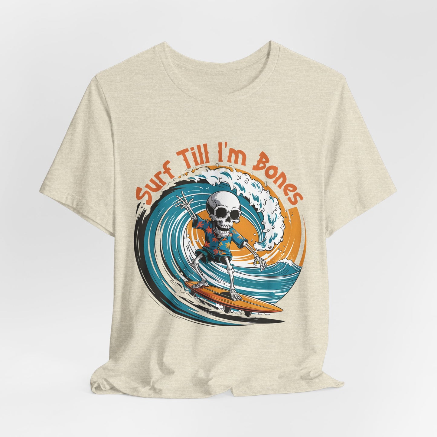The Surf Till Im Bones Unisex Jersey Tee features a cartoon skeleton surfing a blue wave with “Surf Till I’m Bones” in orange—perfect for beach lovers. Fun skull surfing graphic shirt in beige.