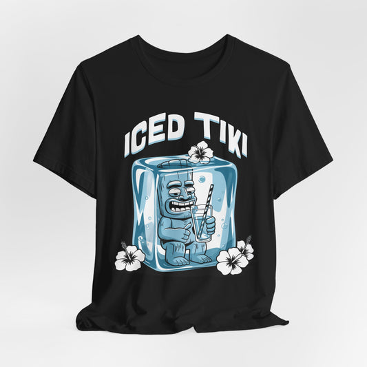 The Iced Tiki Unisex Jersey Tiki T-Shirt - Summer Vibes T-Shirt showcases a cartoon Tiki statue in an ice cube sipping from a straw, accented by white hibiscus flowers. Crafted from breathable, lightweight fabric for all-day comfort.