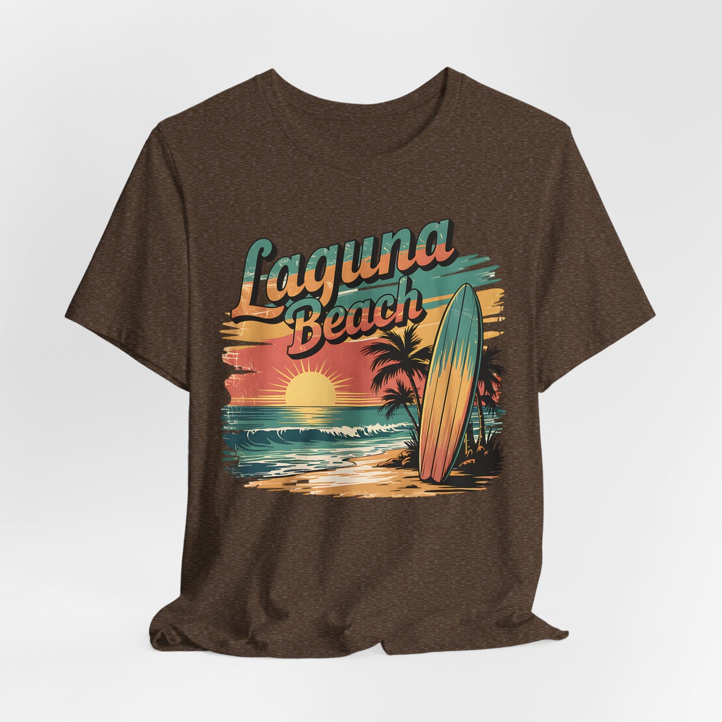 The Laguna Beach Surf Tee - Unisex Jersey Short Sleeve Shirt for Beach Lovers features a retro sunset, ocean waves, palm trees, and surfboard graphic with bold Laguna Beach lettering—ideal for beach enthusiasts.