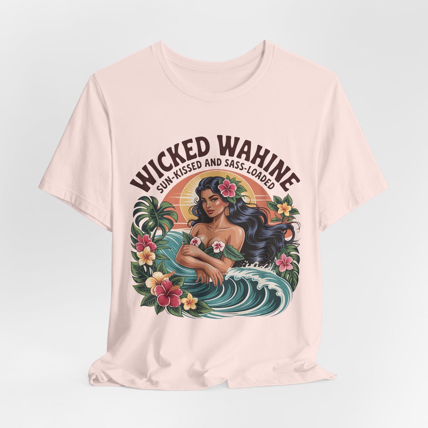 The Wicked Wahine Graphic T-Shirt is a cream unisex jersey featuring a woman with long dark hair in the ocean and tropical accents, plus “Wicked Wahine” above and “Sun-Kissed and Sass-Laden” below—perfect for laid-back style.