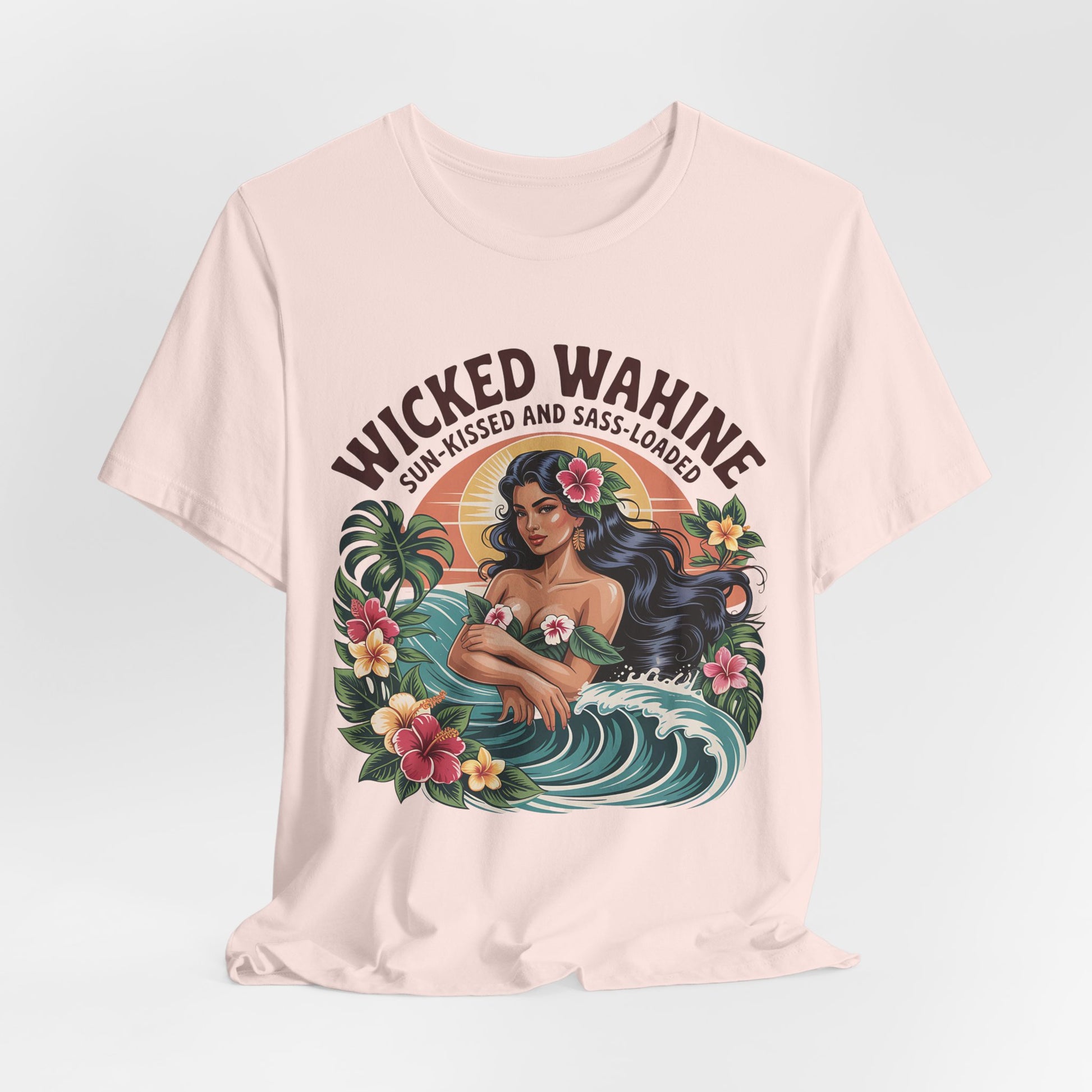 The Wicked Wahine Graphic T-Shirt is a cream unisex jersey featuring a woman with long dark hair in the ocean and tropical accents, plus “Wicked Wahine” above and “Sun-Kissed and Sass-Laden” below—perfect for laid-back style.