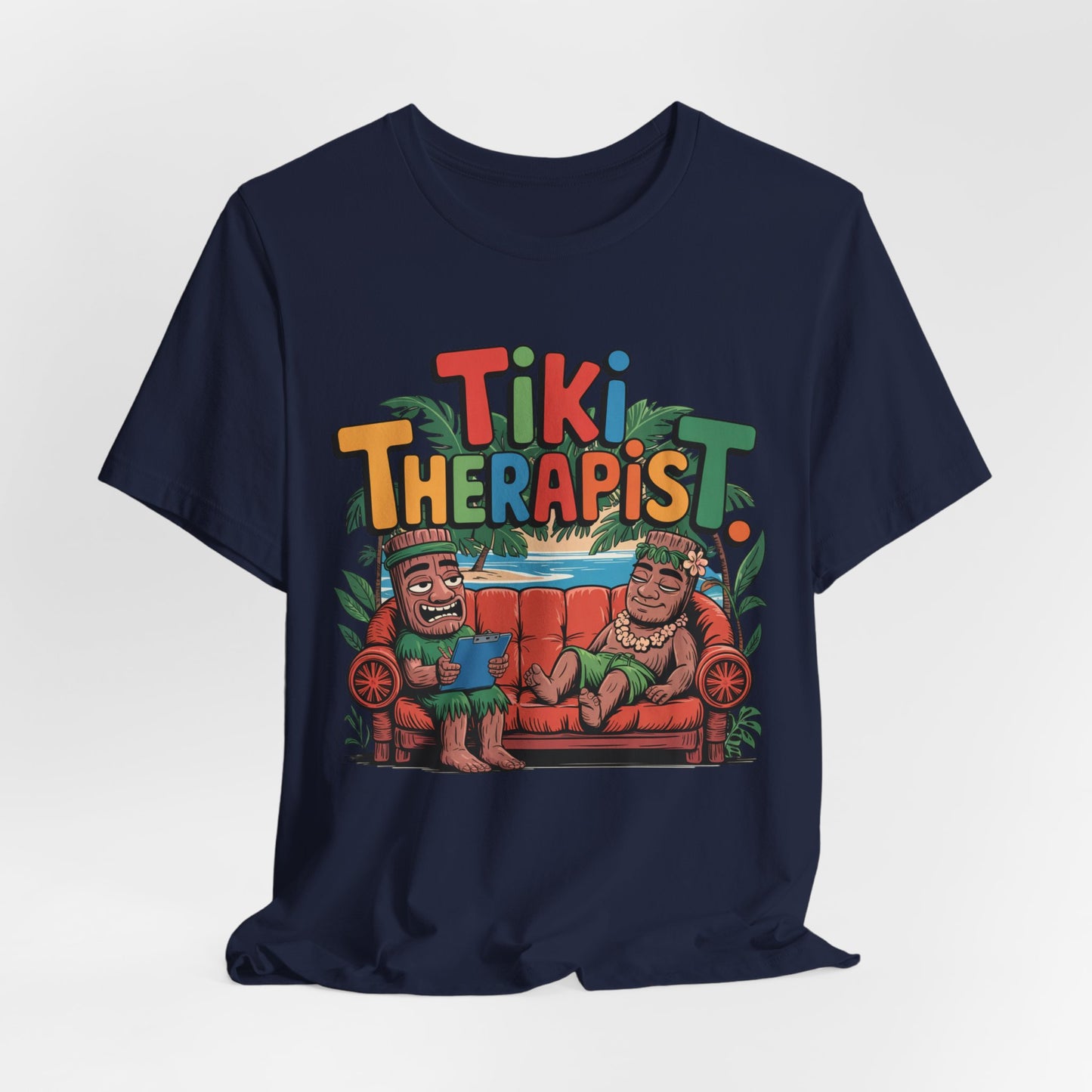 The Tiki Therapist Unisex Tiki T-Shirt is a navy blue cotton tee with two tiki characters on a red couch, playful Tiki Therapist text, and lush leaves—perfect for beach lovers seeking tropical Hawaiian vibes.