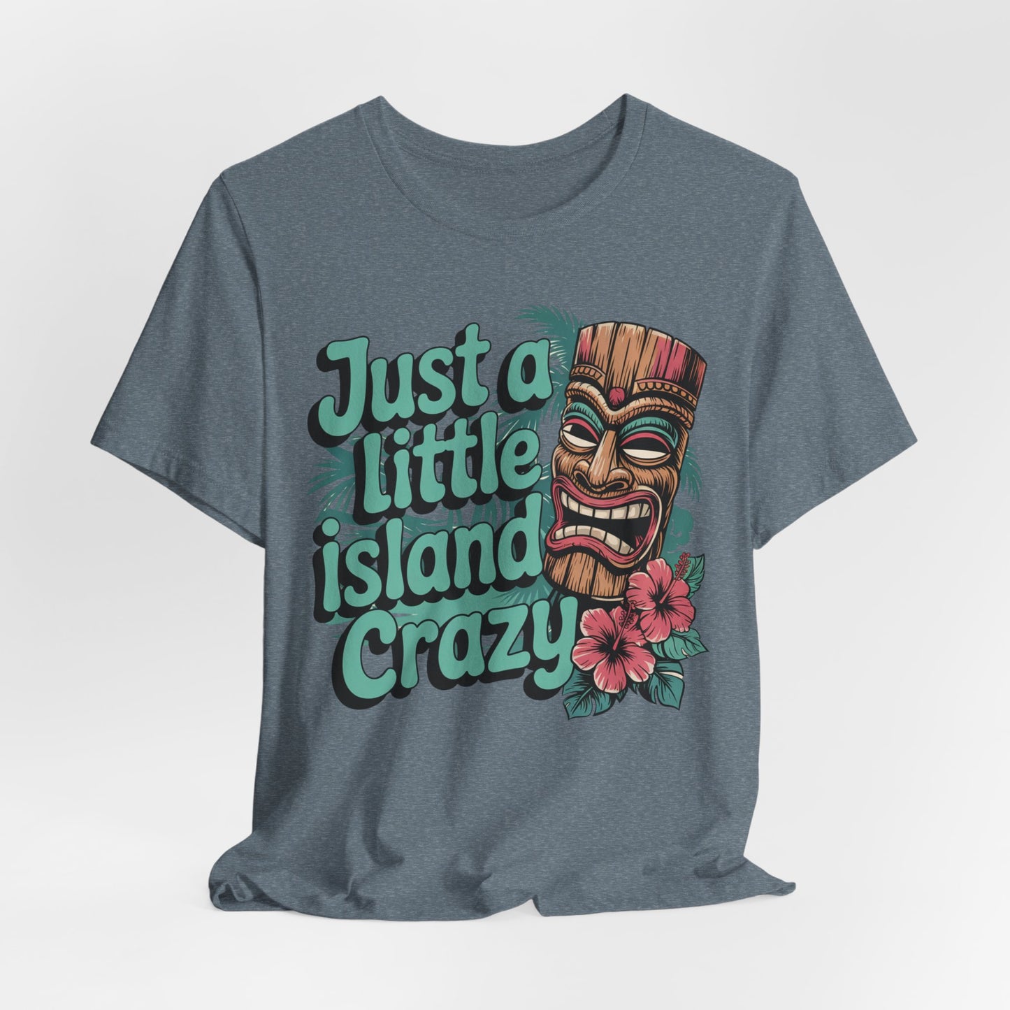 The Tiki Island Crazy Unisex Tiki T-Shirt features a colorful tiki mask, pink hibiscus flowers, and “Just a little island crazy” text—perfect for spreading fun tropical vibes.