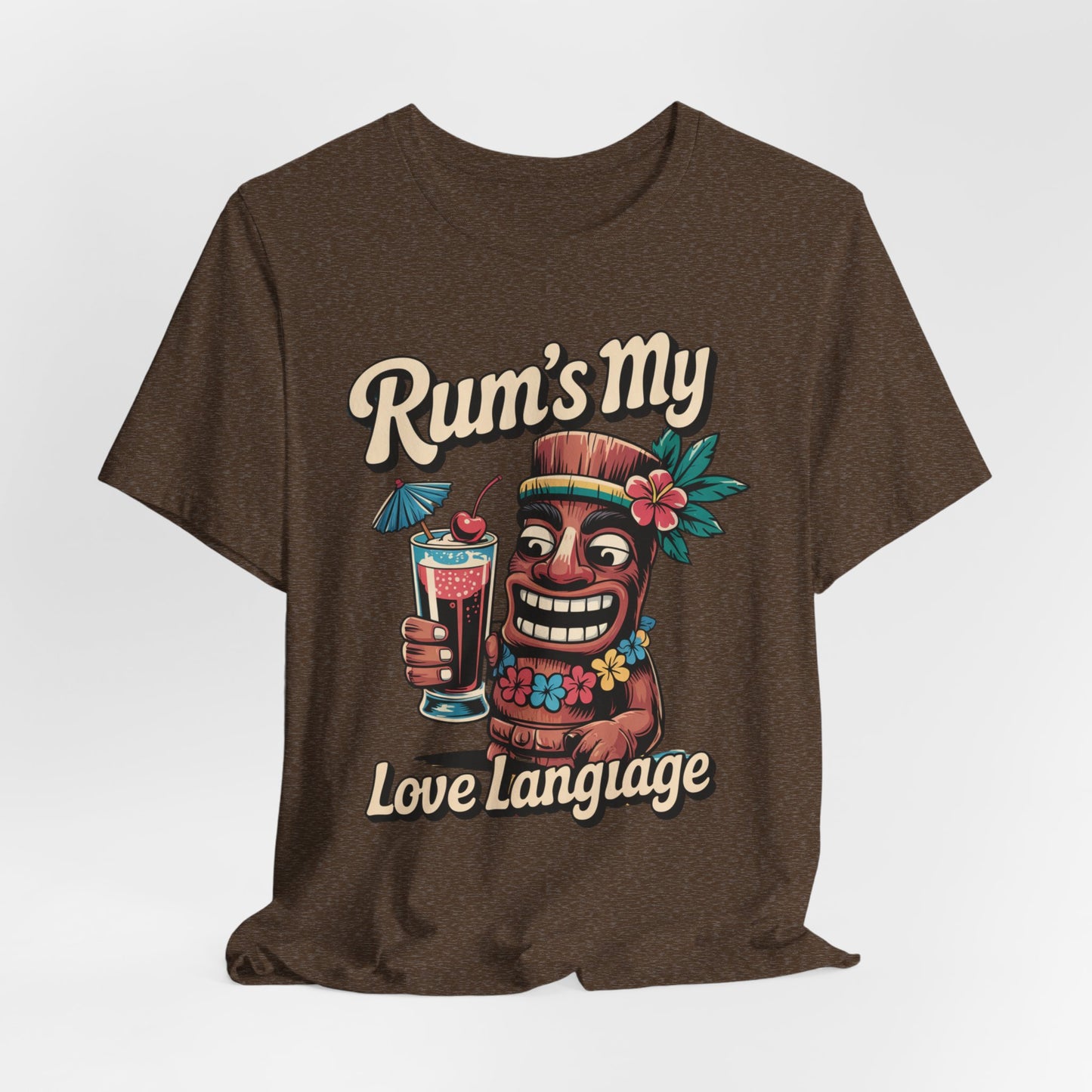 The Tropical Rum Themed Tiki T-Shirt - Rums My Love Language Unisex Jersey Short Sleeve features a vibrant smiling tiki with a tropical drink, flowers, and playful Rums My Love Language text—perfect for fun, tropical vibes.