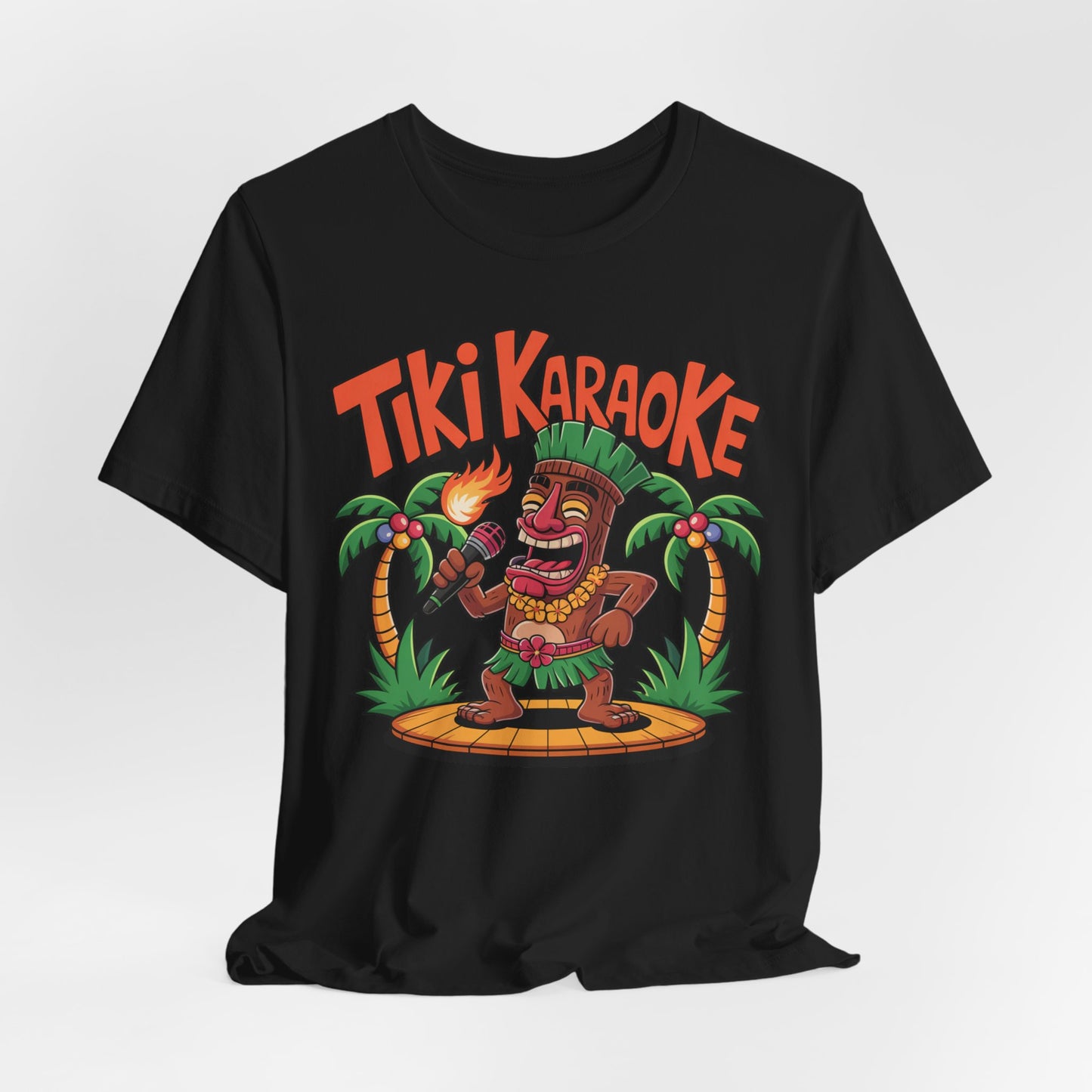 The Tiki Karaoke Unisex Short Sleeve Tiki T-Shirt features a lively cartoon tiki singing into a mic, torch in hand, on a wooden stage with palm trees and bold orange Tiki Karaoke text—perfect for a fun summer vibe.