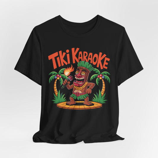 The Tiki Karaoke Unisex Short Sleeve Tiki T-Shirt features a lively cartoon tiki singing into a mic, torch in hand, on a wooden stage with palm trees and bold orange Tiki Karaoke text—perfect for a fun summer vibe.