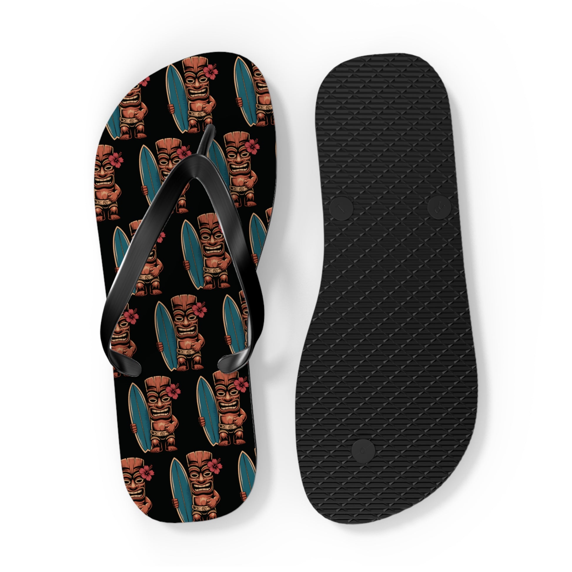 The Tiki Surf Flip Flops - Fun Summer Beach Sandals feature one sandal with colorful tiki statues holding surfboards on a black background, and the other with a plain black textured sole.