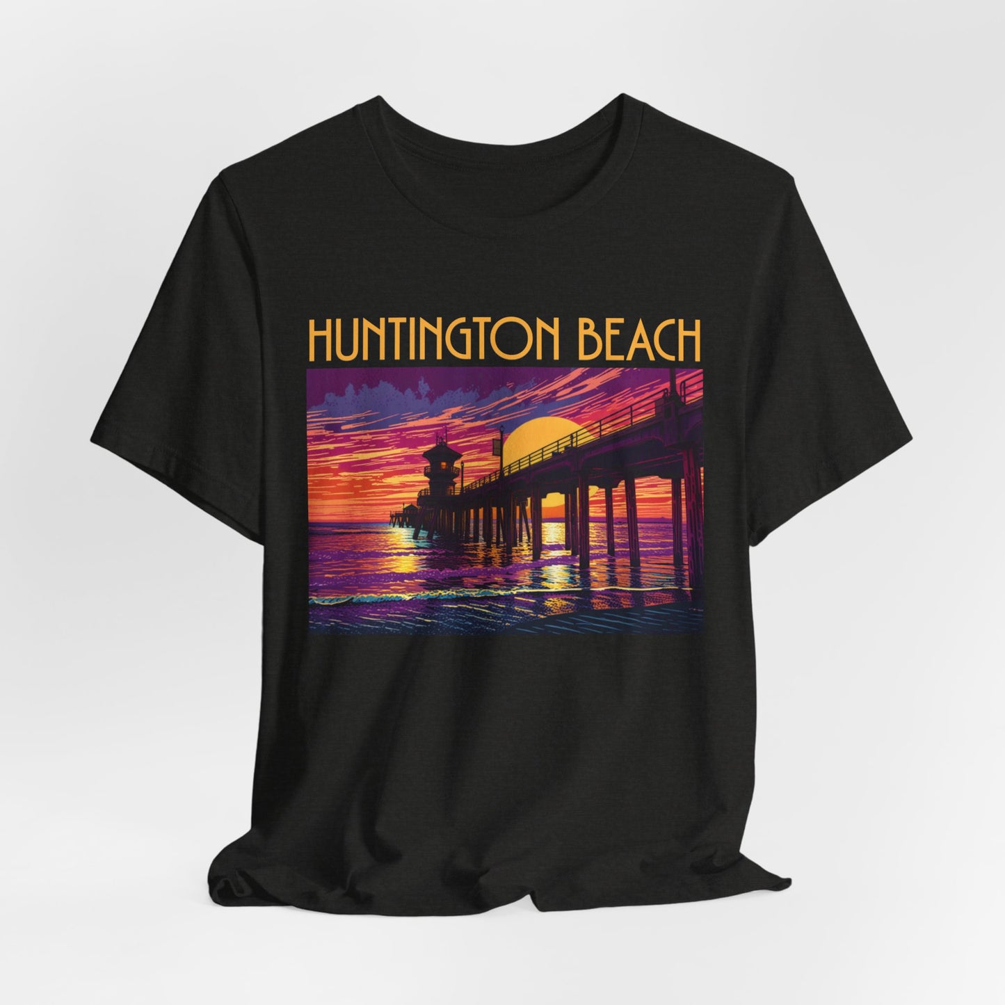 The Huntington Beach Sunset T-Shirt - Unisex Jersey Short Sleeve T-Shirt features a colorful pier-at-sunset graphic and bold yellow “Huntington Beach” text, capturing the lively beach culture vibe.
