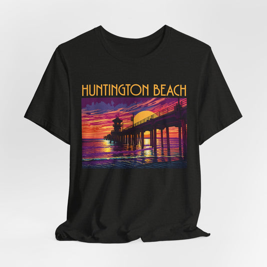 The Huntington Beach Sunset T-Shirt - Unisex Jersey Short Sleeve T-Shirt features a colorful pier-at-sunset graphic and bold yellow “Huntington Beach” text, capturing the lively beach culture vibe.