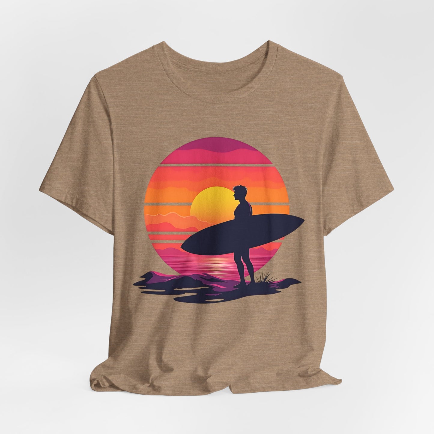 The Sunset Surfing Unisex Jersey T-Shirt is perfect for beach lovers, featuring a tan tee with a surfer and surfboard silhouette against a vibrant sunset. Durable DTG printing ensures vivid, long-lasting colors.