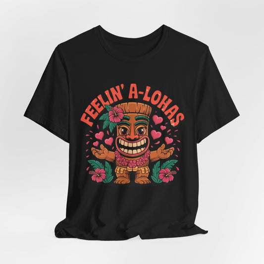 Feelin A-Lohas Unisex Jersey Tiki T-Shirt – features a colorful cartoon tiki, hearts, and hibiscus flowers with “FEELIN’ A-LOHAS” in bold orange. This fun tropical graphic shirt is perfect for casual wear.