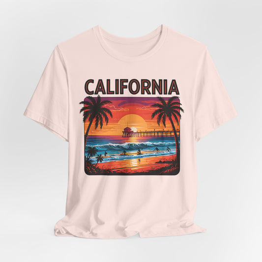 The California Sunset Unisex Jersey T-Shirt features a vibrant beach scene with palm trees, surfers, pier, waves, and bold CALIFORNIA text—perfect for beach lovers and fans of vintage-inspired casual style.