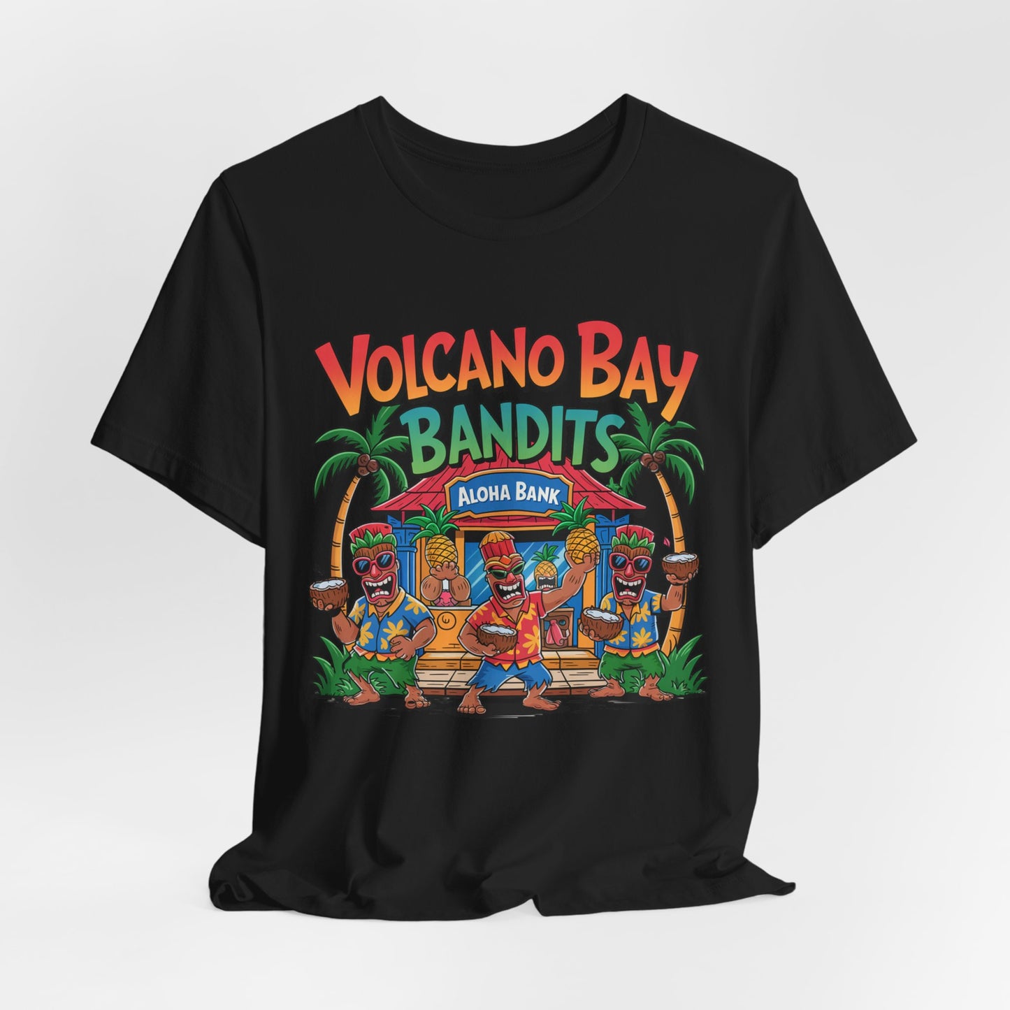 The Volcano Bay Bandits Graphic Tiki T-Shirt is a fun unisex short sleeve jersey featuring colorful cartoon tiki figures by a tropical hut and palm trees, with “Volcano Bay Bandits” and “Aloha Bank”—great for adventure or casual wear.