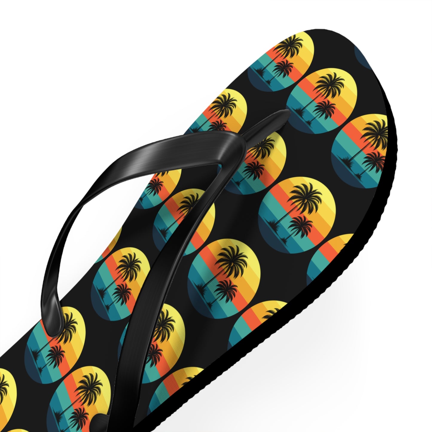 The Tropical Sunset Flip Flops feature black straps and a black base accented with yellow, red, and teal palm tree sunset designs—perfect for beach lovers wanting to upgrade their summer wardrobe.