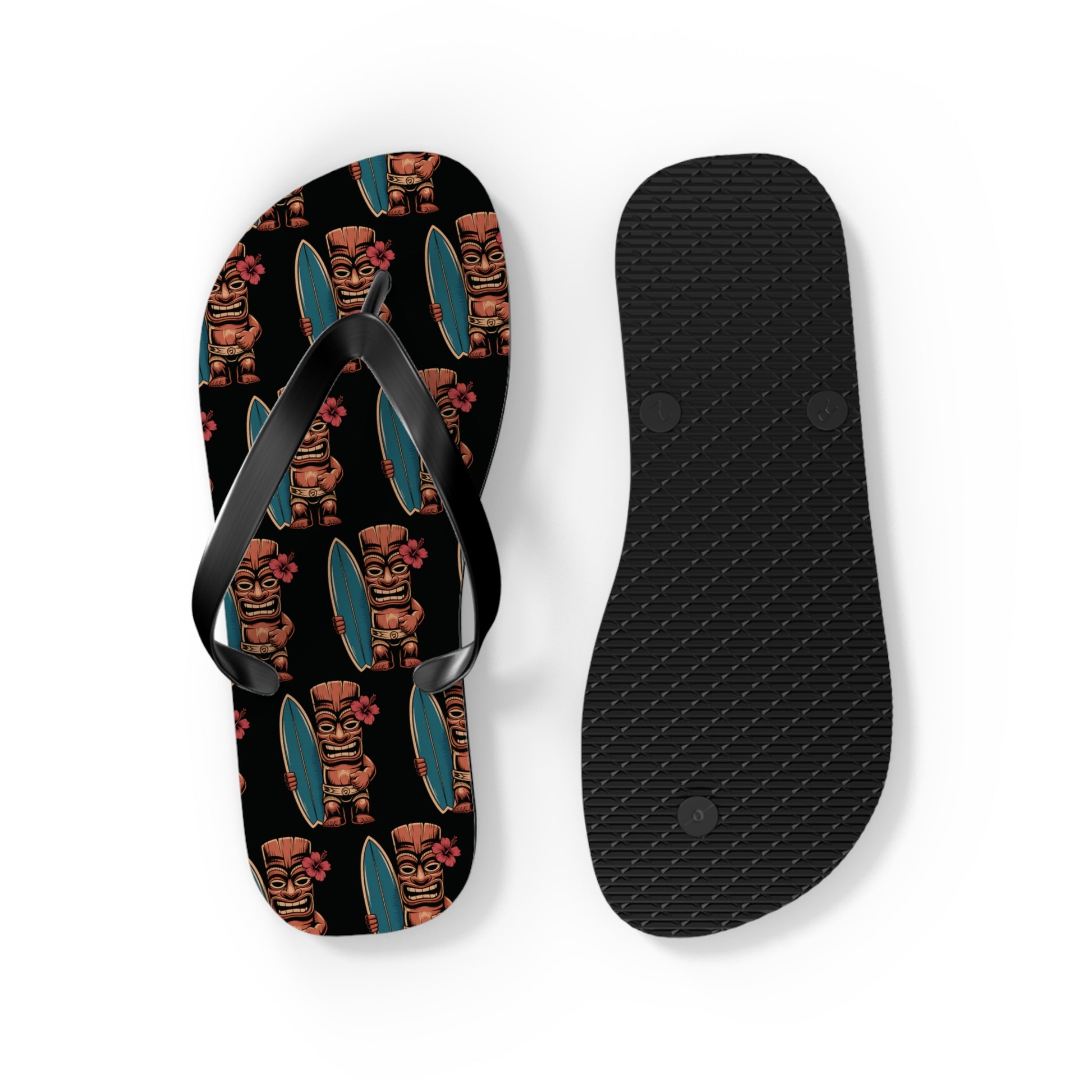 The Tiki Surf Flip Flops - Fun Summer Beach Sandals feature a left sandal with a black sole adorned with vibrant tiki and surfboard prints, a right sandal with a plain black textured bottom, and both have sleek black straps.