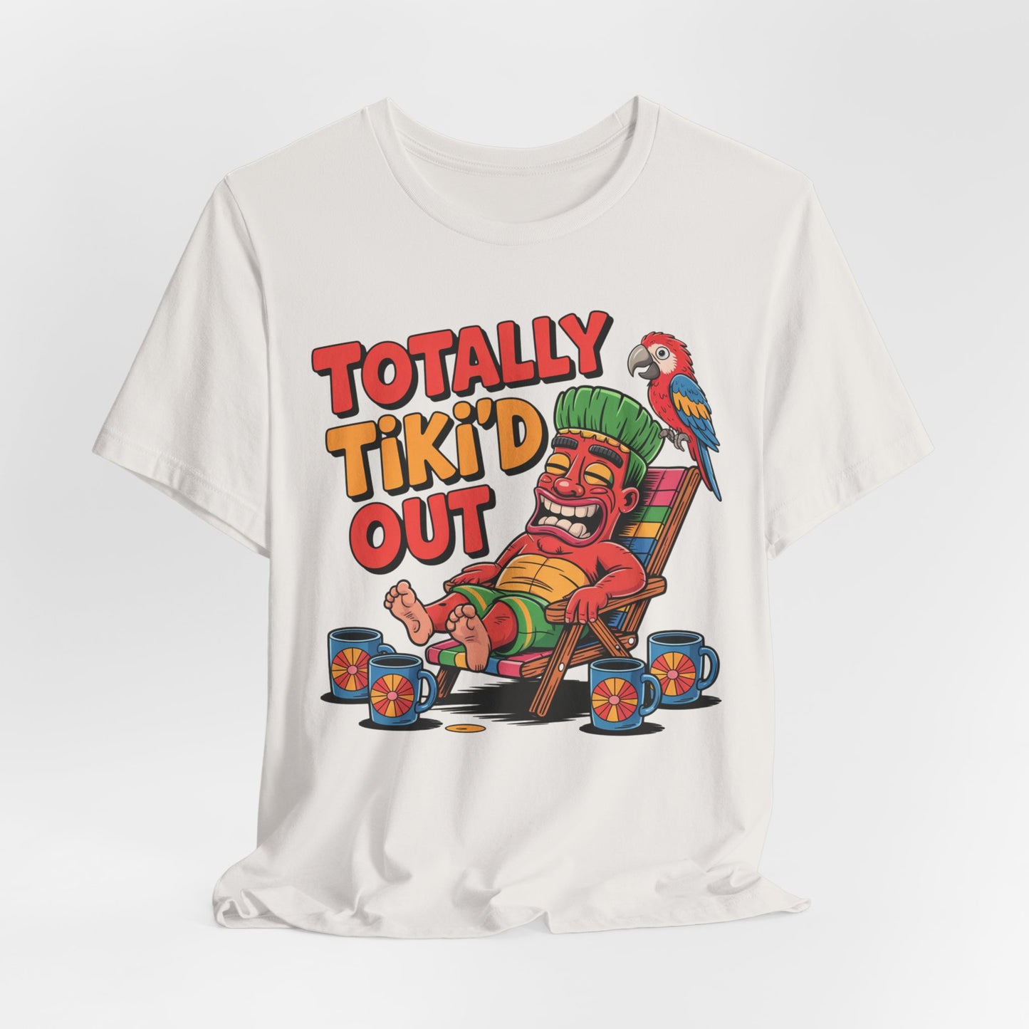 The Tiki Vibe Short Sleeve Tee - Totally Tikid Out Graphic showcases a vibrant cartoon tiki statue, mugs, and a parrot beneath the fun “TOTALLY TIKI’D OUT” slogan—ideal for anyone with major tiki spirit.