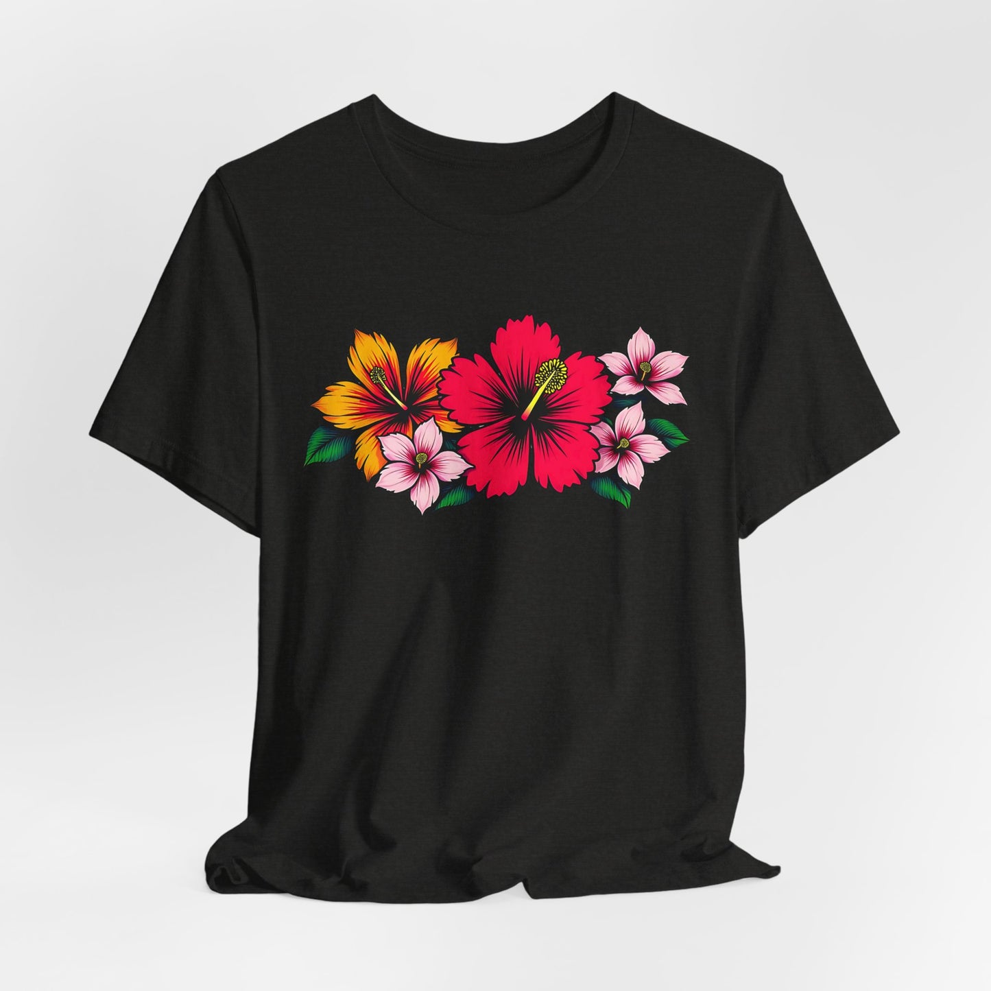 The Tropical Floral Unisex Jersey T-Shirt features a bold red hibiscus with yellow and pink blooms on green leaves, ideal for summer or beach days. Displayed on a plain white background.
