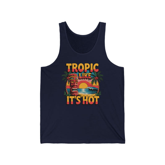 The Tropic Like Its Hot Tank Top - Summer Vacation Essential features a vibrant tiki mask, palm trees, sunset, and ocean waves on navy blue with bold TROPIC LIKE ITS HOT text—perfect for ultimate tropical summer vibes.