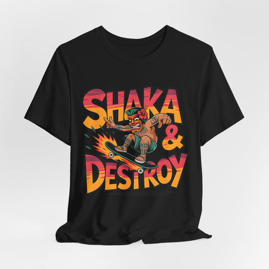 The Shaka & Destroy Graphic Tiki T-Shirt is a unisex jersey tee for skateboard enthusiasts, featuring a vibrant cartoon character skating on a flaming board with bold “SHAKA & DESTROY” text on breathable fabric.