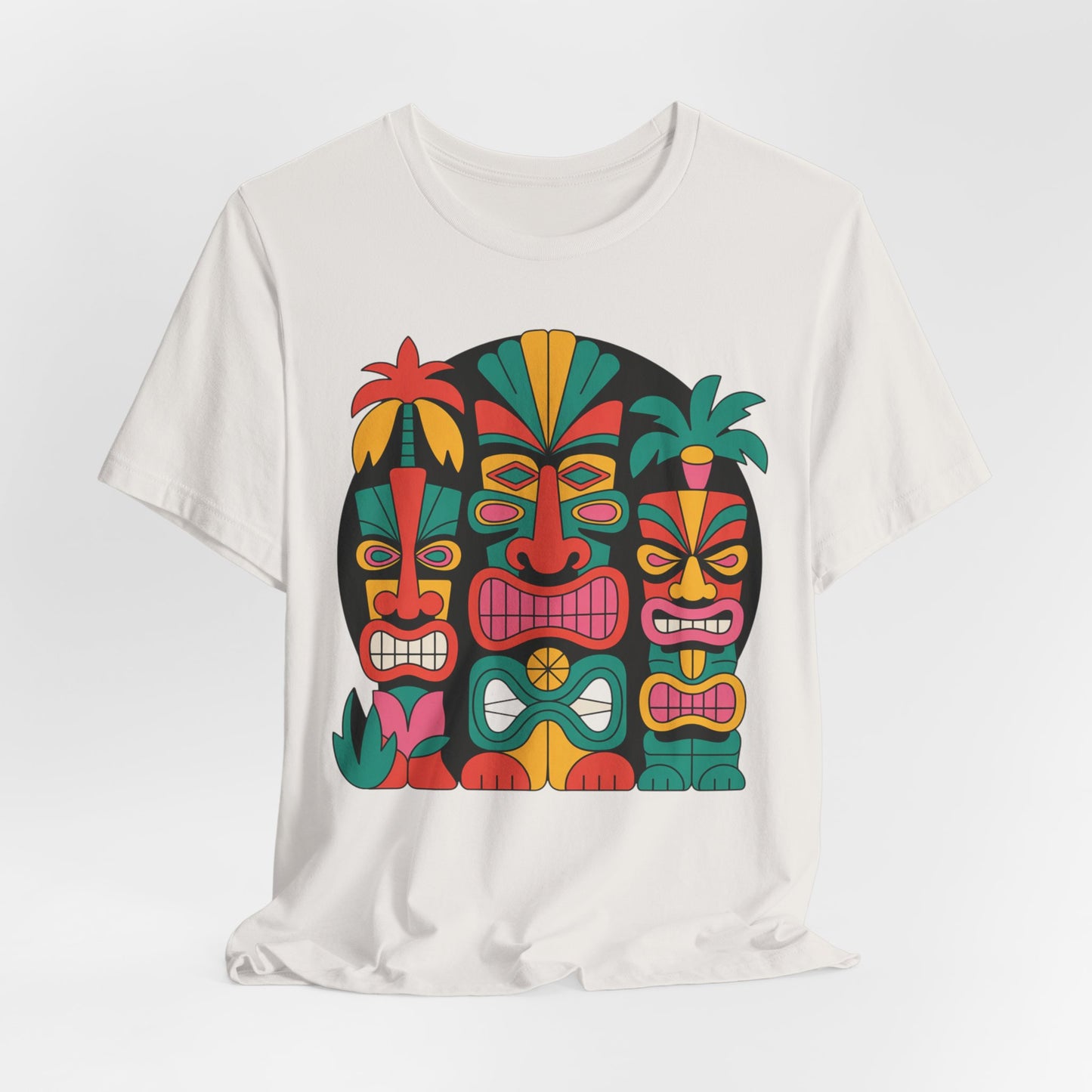 The Tiki Vibes Unisex Tiki T-Shirt features three abstract tiki masks with bold shapes and stylized palm leaves in red, green, yellow, and teal on a black circle, creating a vibrant tropical look for beach lovers.