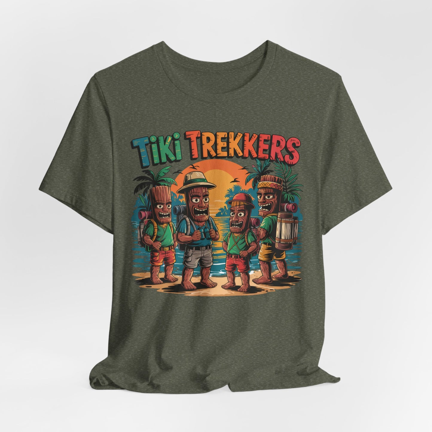 The Tiki Trekkers Graphic Tiki T-Shirt is a green unisex jersey tee with four explorer tikis on a sunset beach, palm trees, and colorful Tiki Trekkers text—perfect for adventure lovers and outdoor enthusiasts.