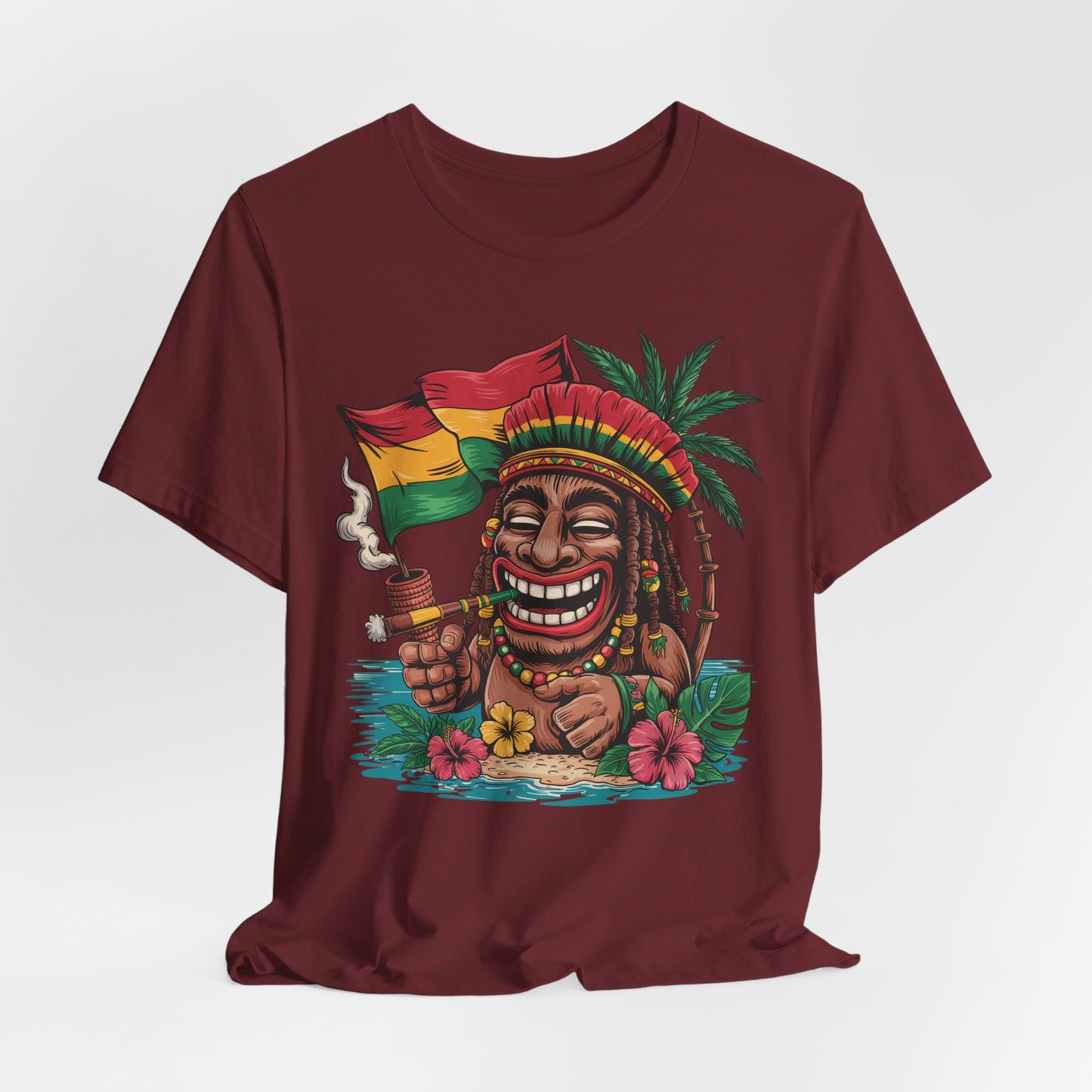 The Tropical Vibes Unisex Jersey Tiki T-Shirt features playful art: a smiling figure with a red, yellow, and green hat holding a matching flag, relaxing on an island with palm trees, flowers, and vibrant tropical details.
