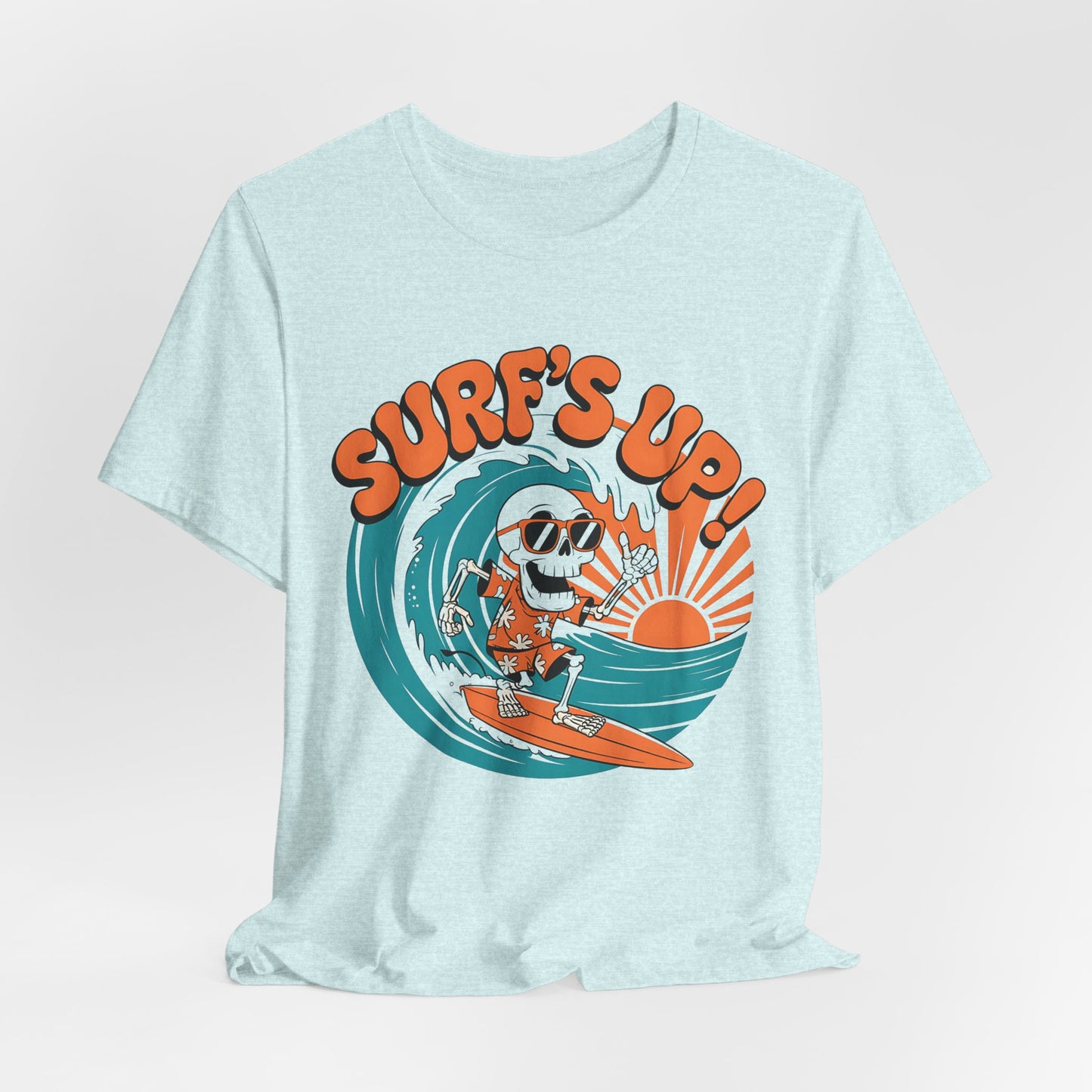 The Surfs Up Skeleton Unisex Jersey Tee is a light blue short sleeve shirt with a cartoon skeleton in sunglasses and a red floral shirt surfing under the sun, plus bold orange SURFS UP!—perfect for beach vibes or summer outings.