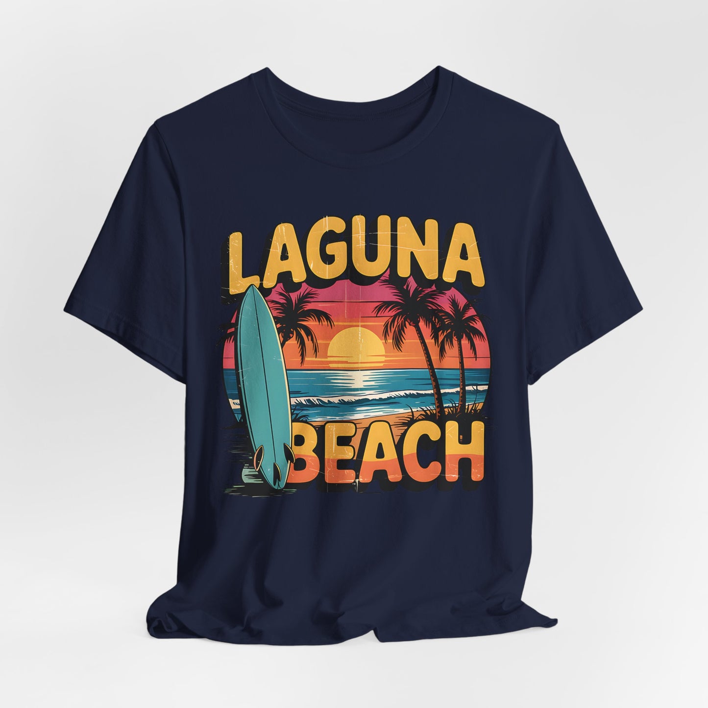 The Laguna Beach Sunset Surf Tee - Unisex Jersey Short Sleeve T-Shirt boasts a navy blue design with a retro sunset, palm trees, ocean waves, and a surfboard. Its relaxed fit and bold yellow text are ideal for any beach adventure.